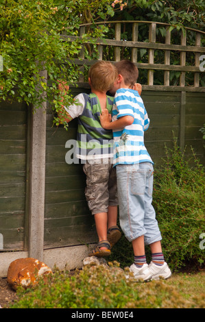 Un modello rilasciato foto di due ragazzi del peering attraverso la recinzione nel Regno Unito Foto Stock
