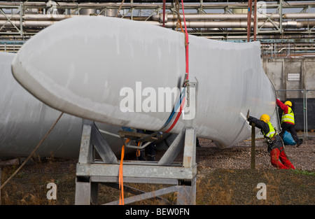 Riggers preparazione di gru per il sollevamento di lame per essere montato a Nordex N90 turbine eoliche in costruzione al Regno Unito Foto Stock