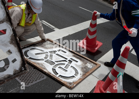 Pittura pista ciclabile della segnaletica stradale in Tokyo, Giappone, martedì 27 luglio 2009. Foto Stock