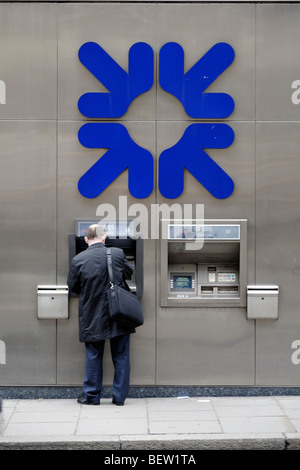 L'uomo prelevare denaro da RBS punto cassa della macchina. Londra. La Gran Bretagna. Regno Unito Foto Stock