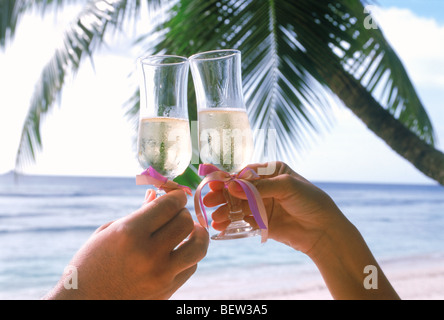 Due persone tostare un'isola incantevole vacanza con bicchieri di champagne Foto Stock