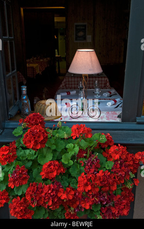 Ristorante con motivi floreali finestra aperta e accogliente lampada la visualizzazione delle tabelle di cui pronto per il servizio Foto Stock