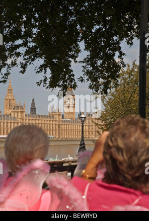 Due donne abbigliate con rosa di ali di farfalla a fotografare il Big Ben e le case del Parlamento dalla parte superiore del double decker bus Foto Stock