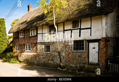 Inglese tipica struttura di legno cottage con tetto in paglia in Ogbourne St.Andrew un paese nel Wiltshire, Inghilterra, Regno Unito Foto Stock