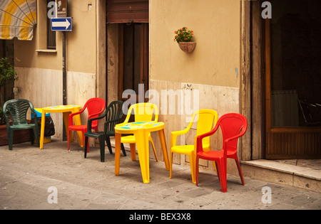 Plastica colorati tavoli e sedie fuori café deserte, Italia Foto Stock