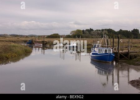 Barche legato lungo Thornham Creek con la marea, una tipica scena costiere lungo il Norfolk barene. Foto Stock