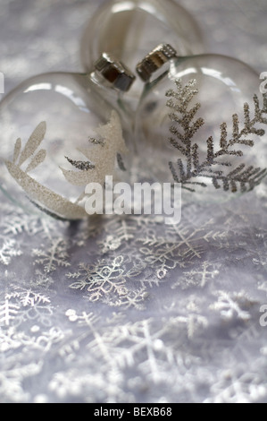 Vetro e argento Christmas tree baubles su bianco e argento materiale colorato Foto Stock