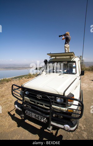 Fotografo in piedi sul veicolo di safari - Lake Nakuru National Park, Kenya Foto Stock