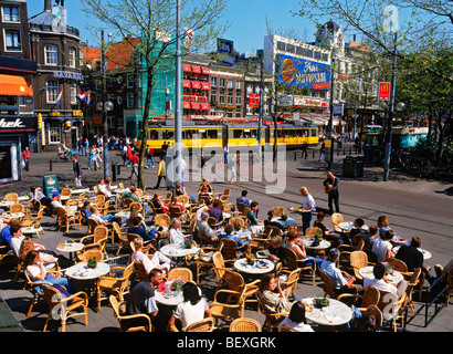 Estate turisti, tram e musicisti di strada al marciapiede esterno ristoranti sulla Rembrandt Platz in Amsterdam Foto Stock