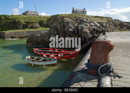 Barche ormeggiate nel porto di pietra al Porto di Ness, isola di Lewis, Scozia Foto Stock