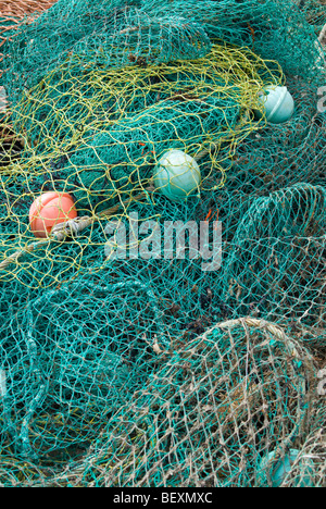 Un groviglio di reti e dei galleggianti impilati su un molo scozzese Foto Stock