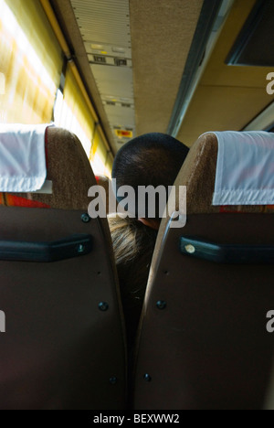 Un giovane addormentato su un autobus a lunga percorrenza Foto Stock