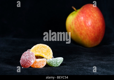 Pila di pastiglia di frutta dolci in primo piano con fuori fuoco apple in sfondo nero Foto Stock