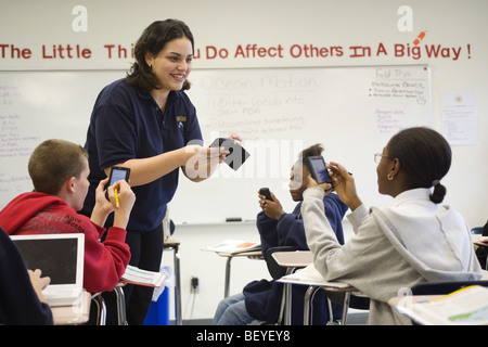 Multi etnico gruppo di studenti in aula con Palm del computer e insegnante femmina, Foto Stock