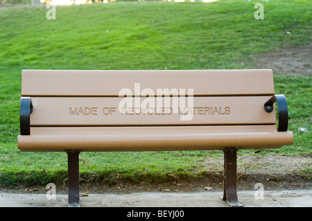 Una panchina nel parco con un chiaramente visualizzato messaggio indicante che è fabbricato con materiali riciclati. Foto Stock