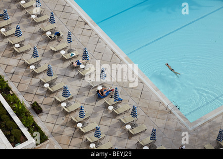 Nuotatore solitario in una piscina scoperta con lucertole da mare a lato della piscina, ritaglia/close up Foto Stock