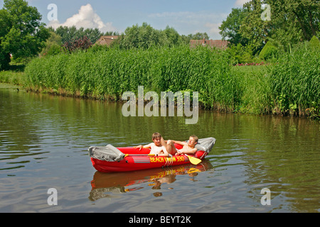 2 ragazzi adolescenti in un gommone sulle rive di un fiume Foto Stock