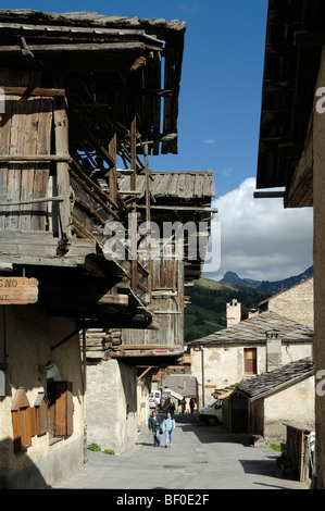 Coppia di turisti a piedi lungo la strada principale di La Ville District Saint-Véran o Saint Veran Village Queyras Alpi Francia Foto Stock