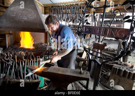 Un fabbro ferraio di villaggio di forgiare un nuovo segno per Ditchling nel Sussex Foto Stock