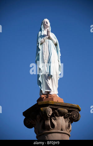 Vergine Maria statua in preghiera. Alsace Francia. Blue sky 099607 Alsazia Foto Stock