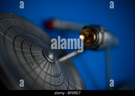 Un modello di peltro del famoso Starship USS Enterprise, da TV Star Trek, visualizzato su uno sfondo blu. Foto Stock