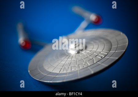 Un modello di peltro del famoso Starship USS Enterprise, da TV Star Trek, visualizzato su uno sfondo blu. Foto Stock