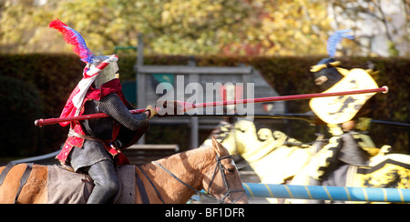 Cavalieri alla giostra sul suo destrier. Il Robin Hood Pageant organizzato dal Consiglio Comunale di Nottingham e detenuti nei giardini del castello di Nottingham. Migliaia di persone visiut questo evento annuale. Il Bailey inferiore ha un medievale renactment tented encampment e sul verde ci può essere visto giostre, falconeria e uomini in armi Foto Stock