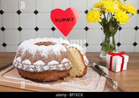 Una torta di Bundt, fiori e un regalo per la Festa della mamma Foto Stock