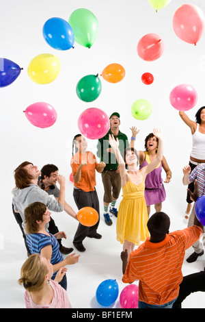 Un gruppo di giovani adulti raggiungendo per palloncini flottante Foto Stock