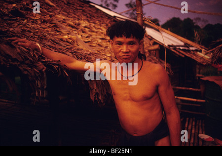 Penan in piedi al di fuori del riparo sulap home casa lunga al tramonto. La foresta pluviale tropicale nel Borneo, Sarawak Malaysia Foto Stock