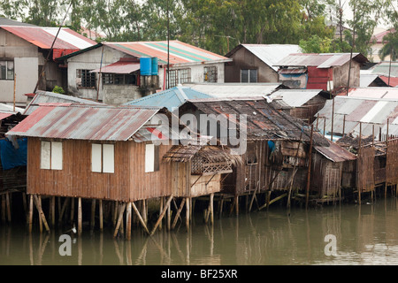 Shanty case su palafitte accanto a un fiume. Iloilo philippines Foto Stock