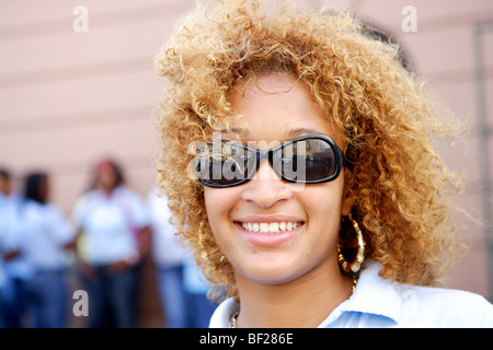 Sorridente giovane donna che indossa gli occhiali da sole, Puerto Rico, Caraibi, America Foto Stock
