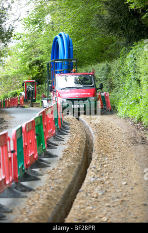 Acqua principali essendo prevista trincea scavata dalla macchina di scavo in Hampshire Inghilterra Foto Stock