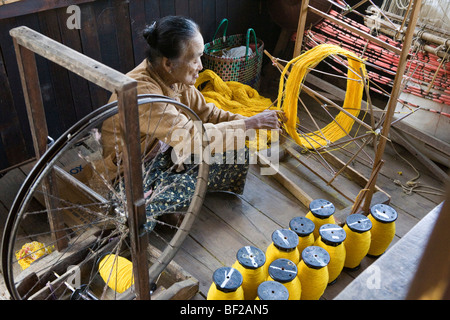 Il vecchio le donne della tribù Intha lavorando su una ruota di filatura, Lago Inle, Stato Shan, MYANMAR Birmania Foto Stock