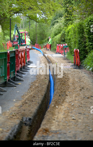 Acqua principali essendo prevista trincea scavata dalla macchina di scavo in Hampshire Inghilterra Foto Stock