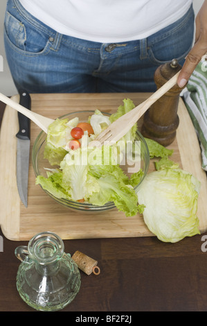 Metà vista in sezione di una donna tossing salad Foto Stock