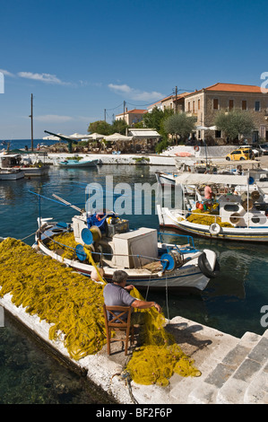 Un pescatore rammendo reti sulla banchina del porticciolo presso Ayios Nikolaos, nella parte esterna di Mani, sud del Peloponneso, della Grecia. Foto Stock