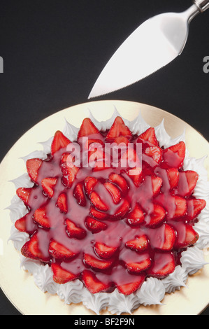 Angolo di alta vista di meringa alla fragola con una torta a server Foto Stock