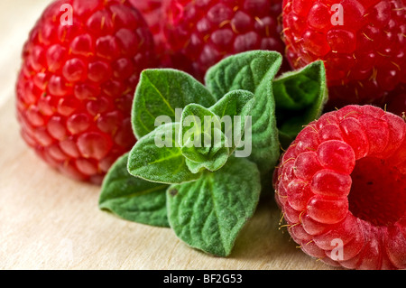 Fresche lamponi maturi e verde con foglie di menta sul backround in legno Foto Stock