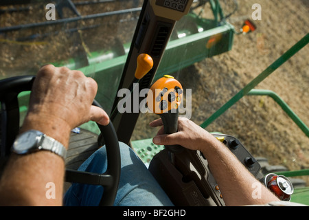 Agricoltura - Le mani di un contadino di azionare i comandi di una mietitrebbia durante il raccolto di soia / Northland, Minnesota, Stati Uniti d'America. Foto Stock