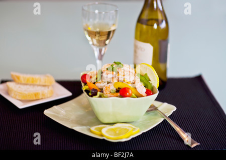 Close-up di insalata di gamberetti servita con vino bianco Foto Stock