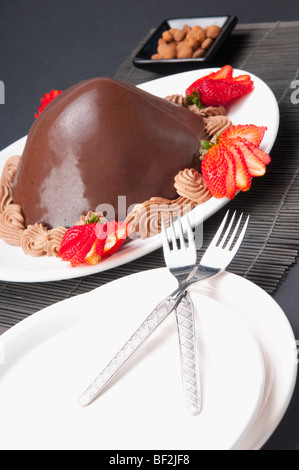 Dolce al cioccolato servito con fragole Foto Stock