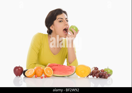 Ritratto di una donna di mangiare una mela verde Foto Stock