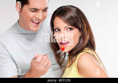 Uomo Donna di alimentazione un pomodoro ciliegino Foto Stock