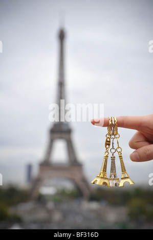 Parigi' famoso punto di riferimento, la Torre Eiffel, con tre anelli chiave penzolante su un dito nella parte anteriore della struttura gigante. Foto Stock
