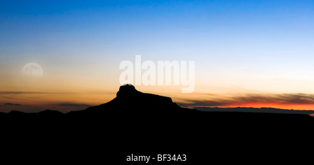 La Luna Piena al tramonto sulla cattedrale montagna vicino a Alpine in Texas la punta nord del deserto del Chihuahuan Foto Stock