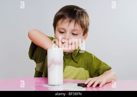 Close-up di un ragazzo dunking cookie nel latte Foto Stock