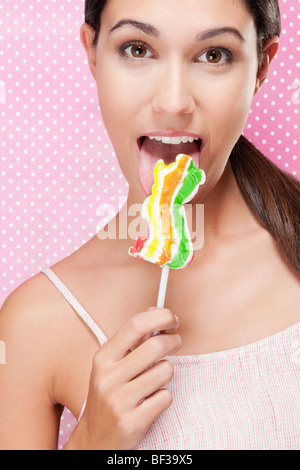 Ritratto di una donna di mangiare un lecca-lecca Foto Stock