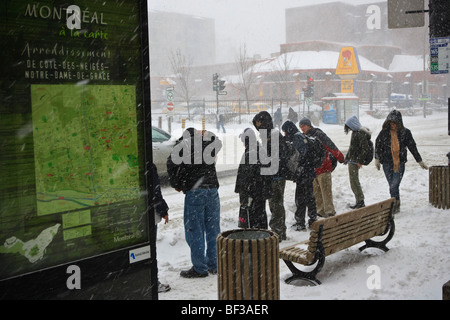 Persone in attesa alla fermata del bus durante un inverno tempesta di neve sul plateau a Montreal. Foto Stock