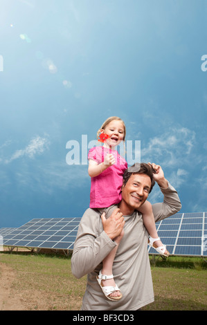 L uomo e la figlia nella parte anteriore del pannello solare Foto Stock